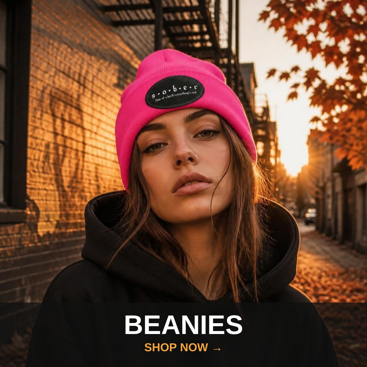 Recovery beanies collection - woman in bright pink S.O.B.E.R. beanie at fall sunset